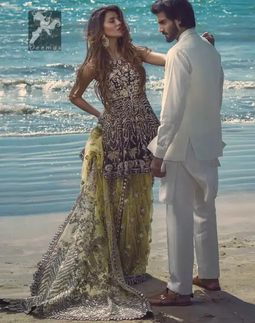 Charade net peplum having halter neckline. Peplum adorned with light golden, pearls and mix embellishment. Husk net sharara and dupatta.