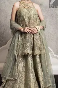 Sage net peplum having halter neck design. Peplum adorned with mix embellishment. Sage brocade plain lehenga. Sage net dupatta finished with piping and having pearls on the sides.