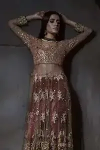 Tea Rose floor length style Anarkali which is fully panelled, embellished with sculptured floral embroidery. Its bodice is fully embroidered with dull golden and antique shades of kora, dabka, pearls and sequins. There is beautiful cutwork and embroidery on sleeves cuff and near the shoulder. Its hemline is adorned with two delicate borders. This dress is artistically coordinated with simple off white brocade lehengha and delicate tissue dupatta with embroidered border on edges. Dupatta is allured with corner appliqued embroidered motifs. There is small floral embellishment pattern on dupatta.