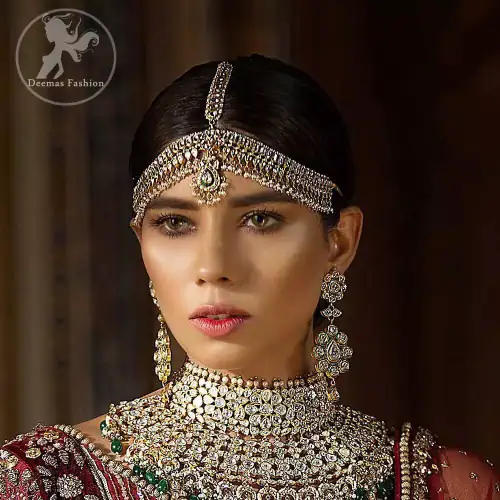 This maroon angrakha frock heavily embellished in the front with silver gold kora dabka, kundan and stones work. One side