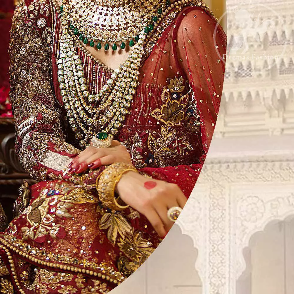 This maroon angrakha frock heavily embellished in the front with silver gold kora dabka, kundan and stones work. One side shoulder neckline is beautifully ornamented with sequins lines in geometric manner. Paired up with matching brocade sharara which looks so magnificent. This outfit is meticulously coordinated with maroon dupatta with embellished borders on lengths.