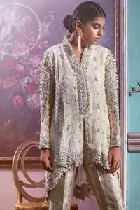 This open short shirt is decorated with Resham thread, kora, dabka, tilla, sequins and pearls. It is self embroidered shirt embellished with floral thread embroidery. Sleeves are fully embroidered. it is further enhanced with an embroidered scalloped border which adds to the look. It comes with brocade bell-shaped pants. It is beautifully coordinated with a chiffon dupatta which is sprinkled with sequins all over.