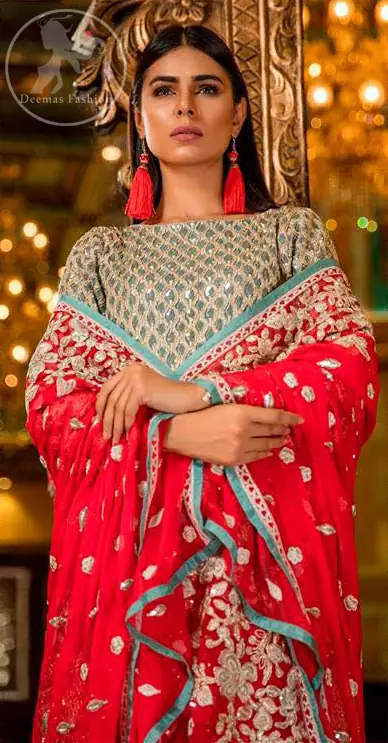This shirt is adorned with floral embroidery.It is allured with silver and white kora dabka, tilla, sequins and swarovski. This outfit is decorated with intricate cut-work pattern on bodice and sleeves as well. It is beautifully paired up with blue smoke gharara pants. It is artistically coordinated with torch red dupatta which has one sided heavy embroidery and sprinkled with sequins all over it.