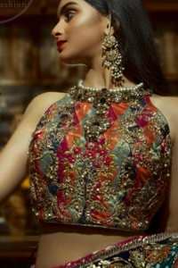 This outfit is a timeless beauty. It is heavily embellished with antique gold kora, dabka, tilla, sequins and swarovski crystals. This exquisite halter neckline blouse is fully decorated with floral motifs patterns all over it. Applique waist belt is decorated with gota and thread embroidery.It comes with embellished lehengha. This Outfit is beautifully coordinated with lime green dupatta with heavy embroidered borders.