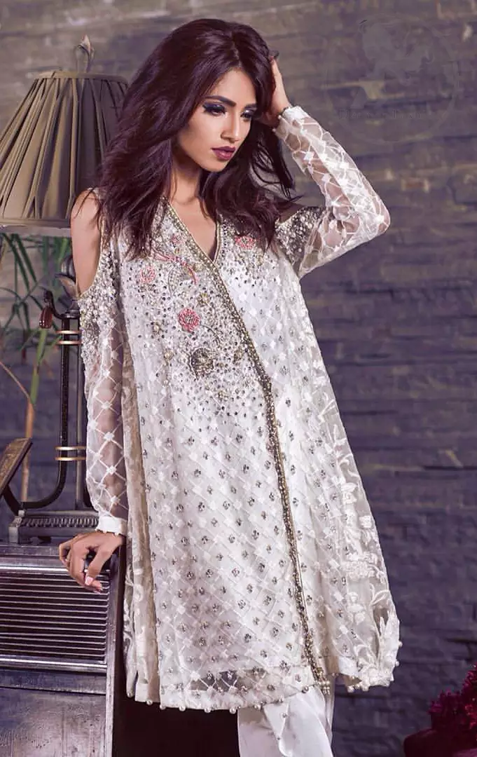 This beautiful angrakha style shirt adorned with embroidered featuring silver and antique shaded kora dabka, tilla, sequins and swarowski. Hemline is decorated with pearls. There is cold shoulder design on sleeves which adds to the look. It comes with brocade pajama.It is coordinated with net dupatta having sprinkled sequins all over it.
