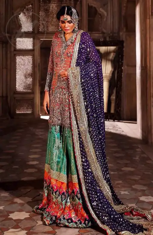 This unique bridal dress is beautifully sculptured with floral thread embroidery. It is meticulously highlighted with silver and antique kora