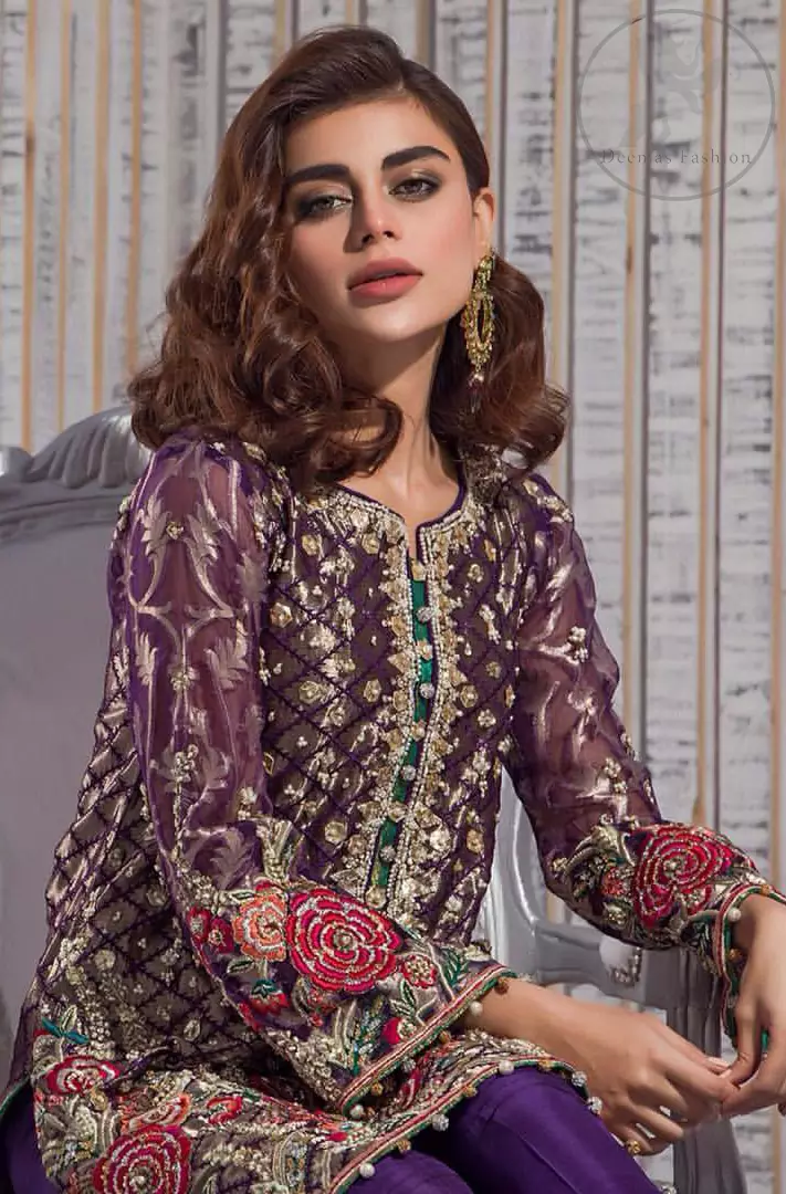This outfit is beautifully sculptured with multiple color floral embroidery. The iridescent organza shirt is adorned with self print criss cross patterns. It is embellished with dull golden kora, dabka, tilla, and sequins work. Neckline is adorned with embellishments. It is artistically coordinated with chiffon dupatta with sprinkled sequins all over it. It comes with purple straight trousers.