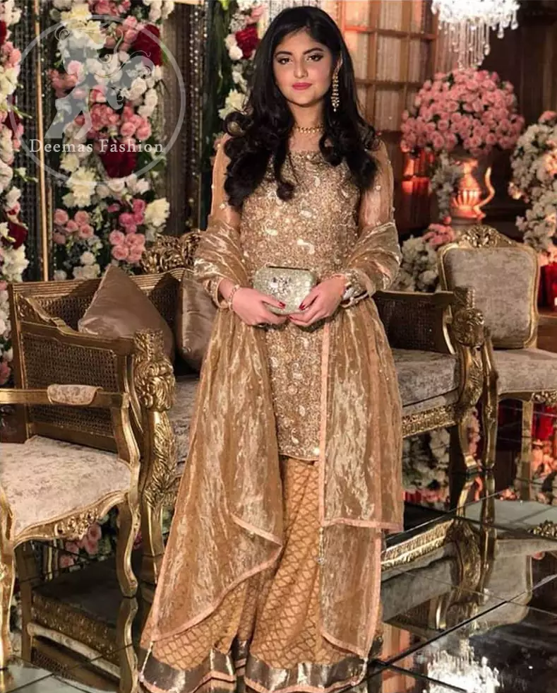 Take a step towards refreshing your wardrobe with this regal dress. The shirt is beautifully adorned with golden kora dabka, kundan, tilla and sequins work along net sleeves. The self-printed brocade sharara is enhanced with lace detail on bottom. It comes with organza dupatta sprinkled sequins on ground.