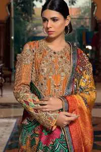 A jaffa color shirt heavily embellished in the front with antique shaded kora dabka, kundan, tilla, sequins and pearls. Floral motifs on the shirt and cold shoulder sleeves enhance the beauty of this shirt. It is finished with scalloped embellishment border. This dress is coordinated with embroidered cigarette pants and self-printed dupatta.