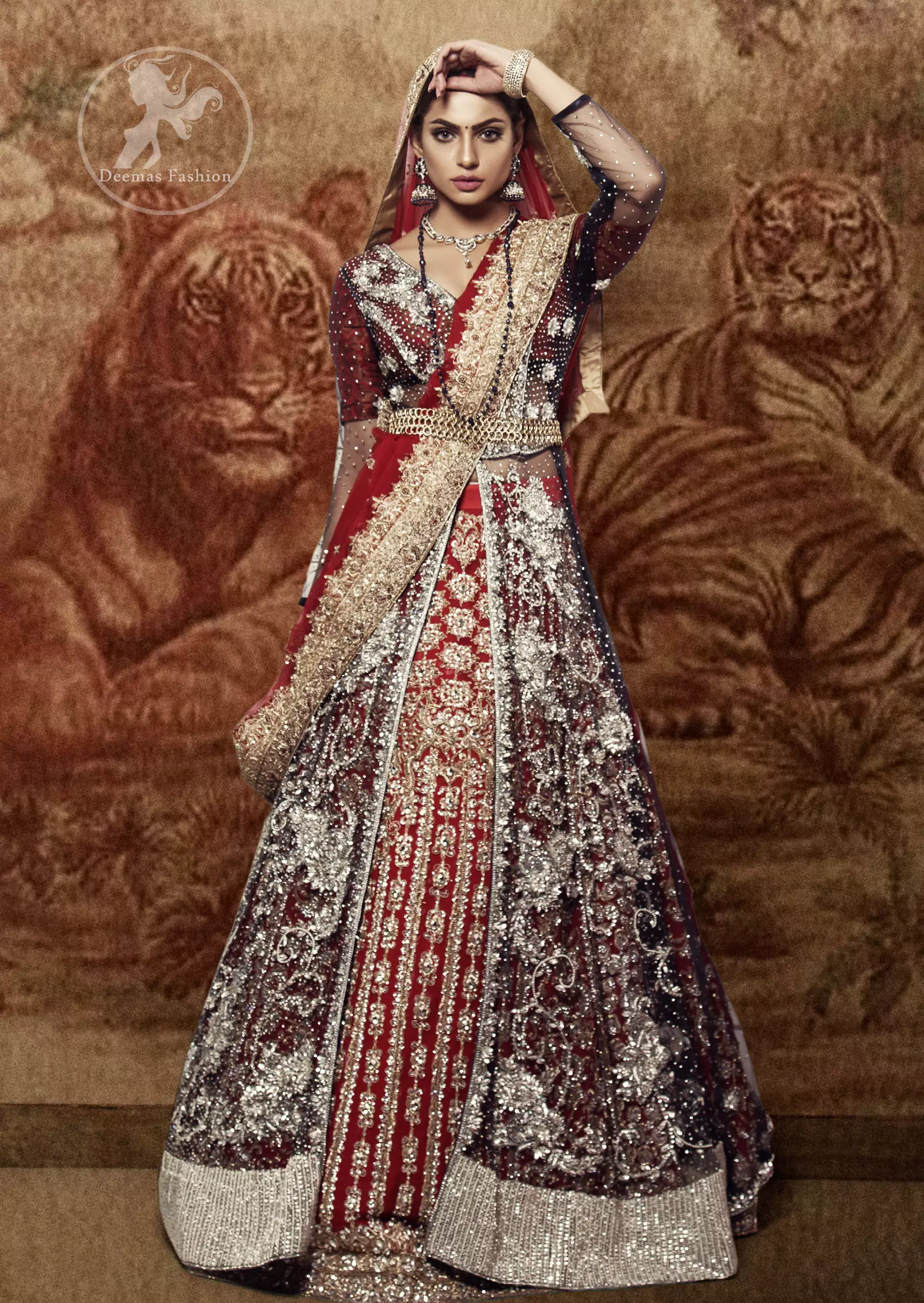 This dress is timeless beauty. Black floor length net paneled gown is beautifully embellished with silver kora dabka, tilla, pearls and sprinkled sequins all over. It comprises with maroon blouse and skirt. The skirt is ornamented with floral motifs done with silver gold kora dabka, tilla, kundan and sequins work. This outfit is coordinated with maroon dupatta with embroidered borders on all four sides and sequins work on the ground.