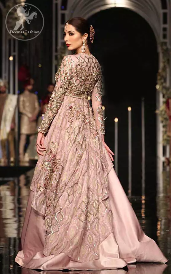 The fusion of unique crafting and a soothing palette lends exquisite elegance and minimalistic sobriety to your opulent evening wear done with light gold kora dabka, kundan and sequins work. It is further enhanced with tilla and sequined geometric embroidery all over. Having full length sleeves and handcrafted belt and fully embellished from back.