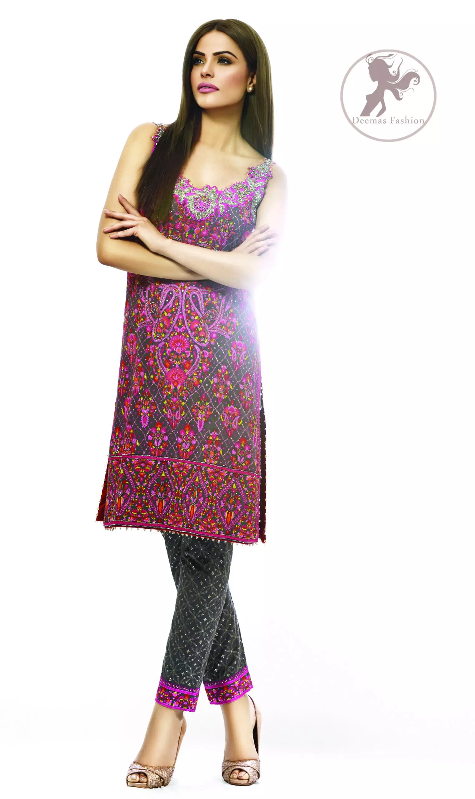 This dress is beautifully sculptured with floral embroidery, adorned with crisscross pattern, colorful embellishments and zerdozi work. The detailed geometric border gives a perfect ending to this shirt.  Having sleeveless sleeves and small sprinkled motifs on shirt. Paired up with cigarette pants which is designed in crisscross pattern. It comprises with magenta chiffon dupatta.