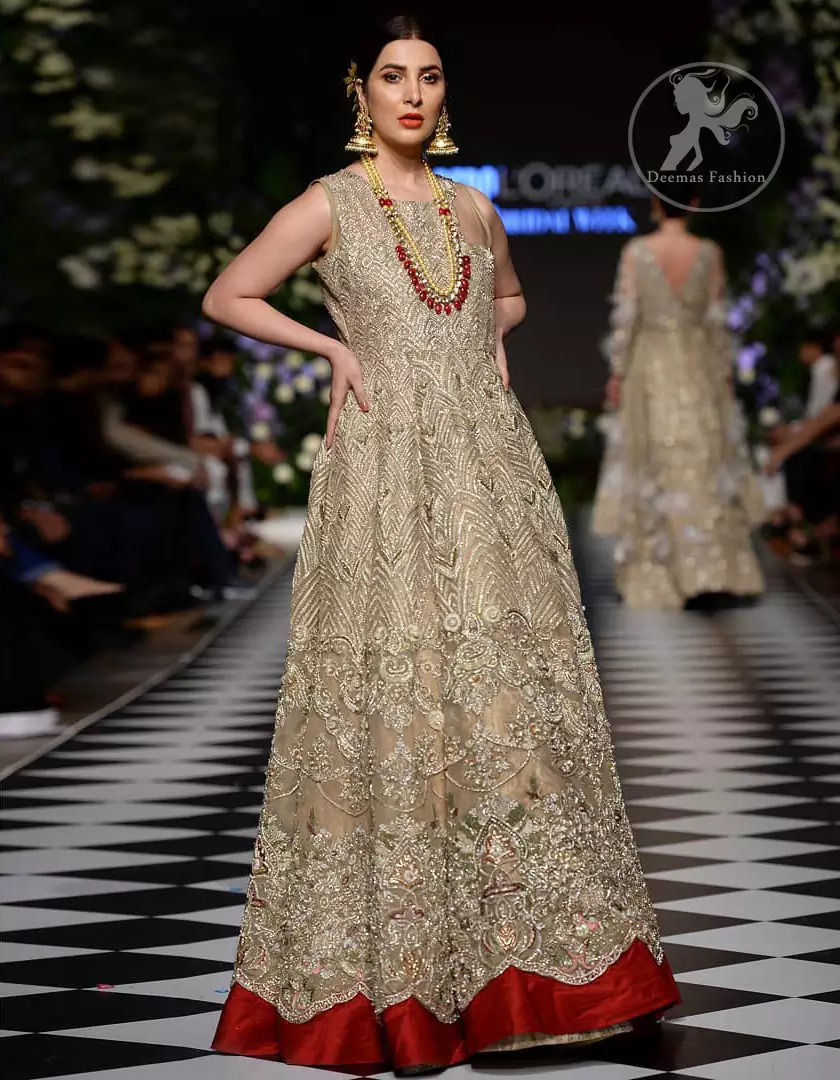Delicately crafted and personifying chic elegance with an element of grandiose. This dress is beautifully sculptured with floral embroidery, adorned with cutwork borders embellished with dull gold and silver kora, dabka, pearl and sequins work all over. Moreover it is enhanced with different styles multiple colored embroidered motifs and finished with marron applique. This outfit comes with brocade pajama. It is coordinated with tissue dupatta which is sprinkled with sequins all over it. 