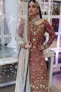 Make a dazzling impression in our zari embroidered copper rust shirt enhanced with intricately embellishmentswith gold and antique gold kora, dabka, tilla, sequins and pearls.It is paired up with thread embroidered chiffon lehengha having appliqued border around. Dupatta is sprinkled with stones all over it.