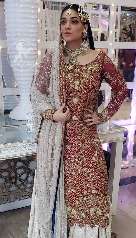 Make a dazzling impression in our zari embroidered copper rust shirt enhanced with intricately embellishmentswith gold and antique gold kora, dabka, tilla, sequins and pearls.It is paired up with thread embroidered chiffon lehengha having appliqued border around. Dupatta is sprinkled with stones all over it.