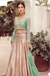 The bridal stands out due to its uniqueness and the perfect fusion of modern cut and traditional embroidery. This dress is beautifully decorated with heavy embroidery. It is highlighted with dull golden kora, dabka, tilla, sequins, pearls and thread embroidery. This outfit comes with salmon pink lehenga which is enhanced with embroidery on bottom. It is coordinated with tissue dupatta which is sprinkled with sequins all over it. It is further furnished with four sided scalloped border.