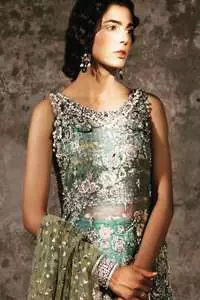 Delicately crafted and personifying chic elegance with an element of grandiose. Heavily embellished in the front with intricate embroidered pattern done with golden and silver kora, dabka, kundan, tilla and sequins. It is further decorated with scalloped boder which having tassels to complete the look. The back of the shirt is embellished with different types of motifs. It comes with matching sharara sprinkled small motifs all over. It is coordinated with olive green chiffon dupatta which is sprinkled with sequins all over it.