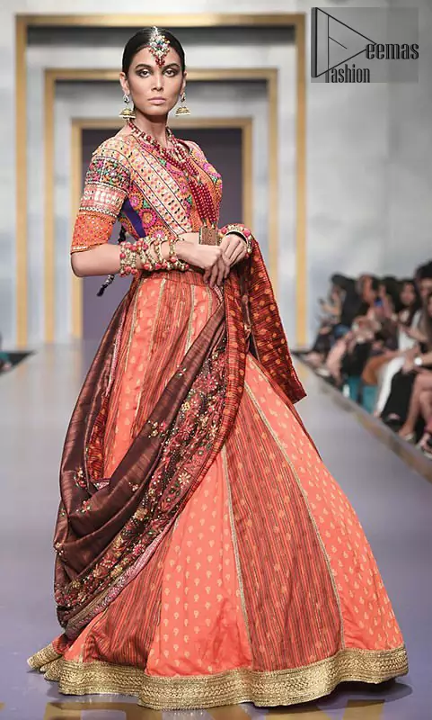 This dress is majestic beauty and perfect for mehndi mayon day. Delicately crafted and personifying chic elegance with an element of grandiose. A full heavily embellished blouse with multiple color resham thread embroidery and mirror work details. Having half sleeves adorned with mirror work. It comprises with self printed lehenga finishing with dull golden lace at the end. Style it confidently with chocolate brown dupatta with thick embellished border on the front and comparatively lighter work border on long edges. Medium and tiny sized ornamental motifs scattered all-over.
