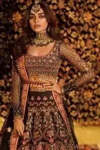 Tradition meets modernity. Go glam in our black traditional lehenga blouse. This outfit bursts of vibrant colors and sumptuous details of zardozi, gota, kora and dabka is a perfect Mehndi ensemble. It is aesthetically designed with thick borders and floral bunches refined the classical royal look. Blouse is decorated with geometric patterns having full sleeves adorned with zardosi work and sprinkled sequins. Style it up with black net dupatta sprinkled with tiny floral motifs and four sided applique embellishment. The piece comes with a handcrafted belt.