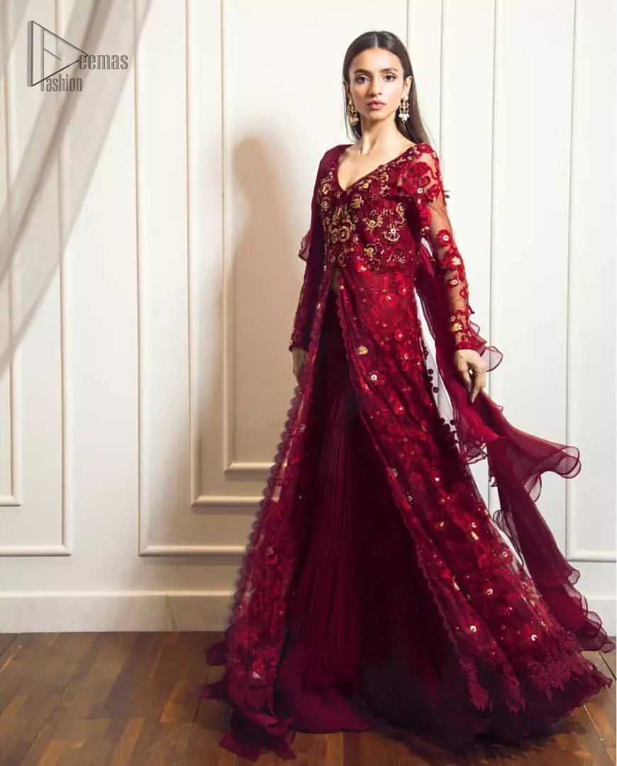 This exceptionally detailed front open gown lehenga is cut in a seductive fit and flare silhouette that’s sure to turn heads on your big day. The bodice with plunging V-neckline is adorned in richly floral lace with fabulous sparkle. Furthermore the bodice is highlighted with golden zardozi work and floral applique. Center slits and bottom of the gown is beautifully decorated with floral lace. It is coordinated with maroon crushed lehenga and organza dupatta. 