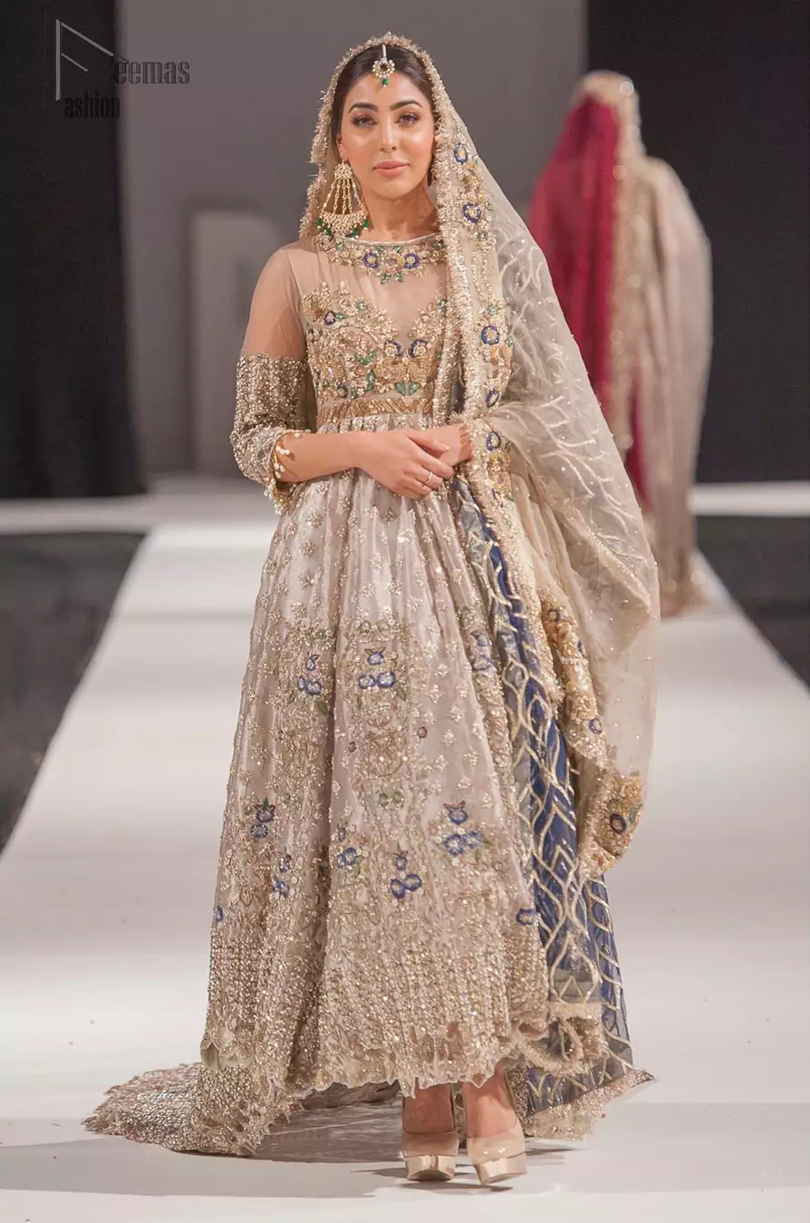 This artisan piece includes intricate hand-embellishment. This technique gives your garments a unique look, and helps to sustain a traditional craft carried out by skilled artisans across Asia. Adorned with dull golden zardozi and multiple color thread embroidery around the neckline and bodice. Furthermore the scalloped bottom is ornamented with floral jhaal, multiple color embellished floral bootis and tiny motif all over. Style it up with gray dupatta done with gotta work and cigarette pants.