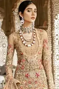 Beautifully elegant with a modern twist. Adorned in an orange embellished with antique detailing all over, this undeniably elegant attire will elevate your style. The shirt is ornamented with antique zardozi and multiple color embroidery detailing all over and vibrant floral motifs. Furthermore the hemline of the shirt is in cutwork style which adds twist. Paired it up with heavily embellished lehenga. The dupatta incorporates beautifully designed scalloped borders on all four sides, focusing on the heavily embellished pallu borders to give it a perfect look.