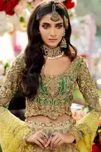 A perfectly pretty combination for a mehndi function. Gussy up the glamour with this intricate embroidered blouse accentuated with golden kora, dabka and tilla work and scalp finishing. The lehenga is emphasized with traditional style done with zardozi work in the shade of golden. Furthermore it is adorned with multiple color applique bottom which complete the look. It is coordinated with yellow dupatta sprinkled with sequins on the ground and scallop border. 