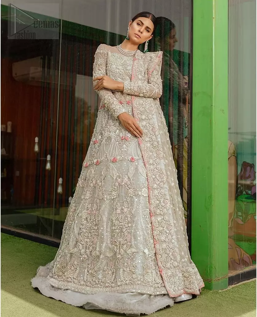 This garnet ensemble is sure to make you look like glamorous royalty with immaculate work covering every inch of the maxi. With a flowing train, this is an ensemble that deserves to be flaunted. The maxi is crafted artfully with silver zardozi work and multiple color thread embroidery. The bodice is heavily decorated with silver kora, dabka and tilla work. Furthermore, scattered sequins all over to give it a perfect look. Balance the look with light gray lehenga adorned with frilled bottom. Dupatta is decorated with vintage floral on pallus and finished with embroidered border on four sides which makes this outfit more beautiful.