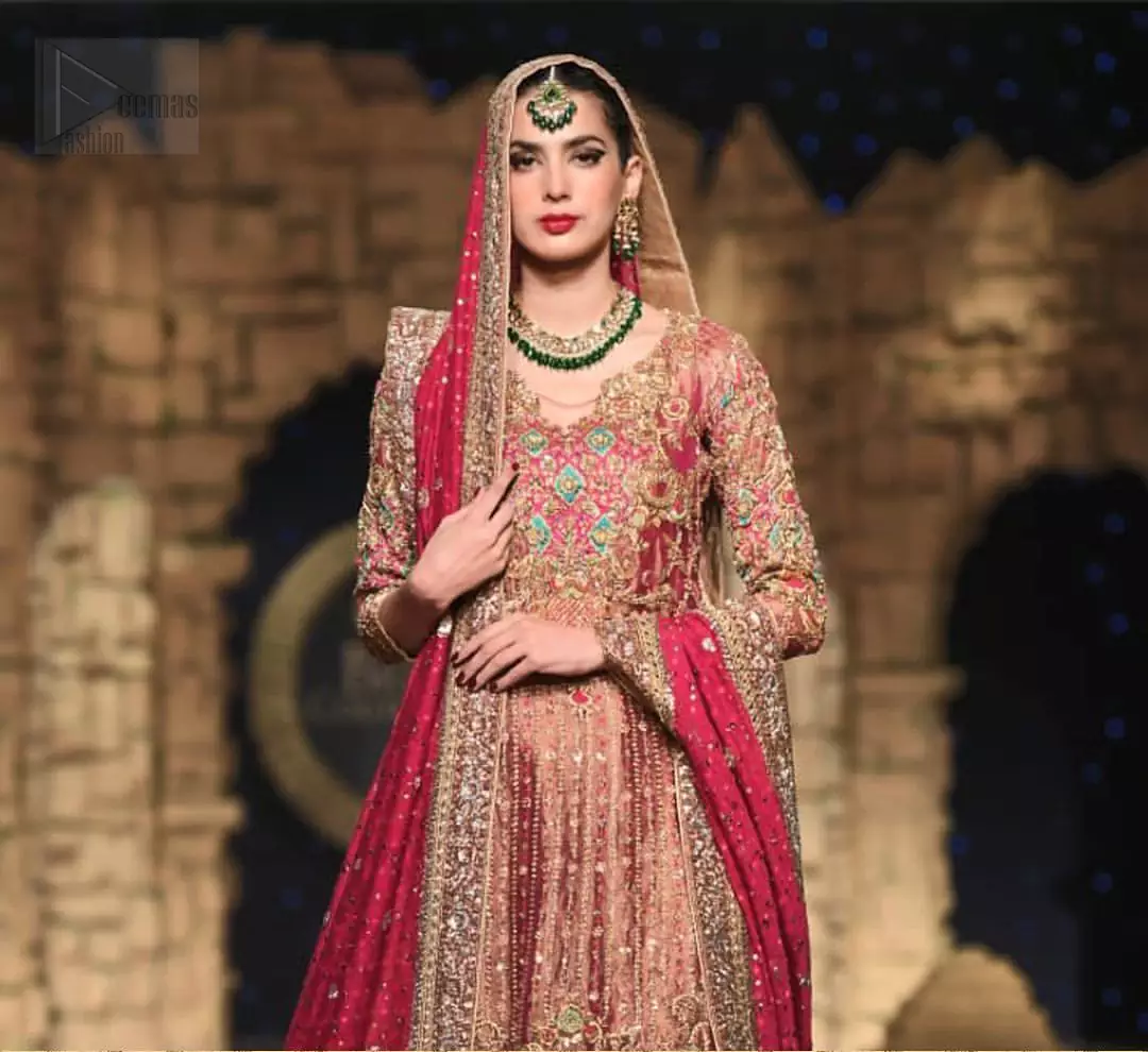 Nothing speaks of femininity and class louder than this outfit. This beautiful dress comes with burgundy A-Line frock with beautiful embellishment around the hem and vertically worked gold lines and it finished with a thick embellished border. The embroidery is done with golden, solver and antique shaded zardozi work. Furthermore it is also enhanced with multiple color thread embroidery in the floral motifs. Style it up with golden brocade sharara done with antique zardosi work at the bottom. This beautiful dress is comprises with burgundy dupatta sprinkled with sequins spray and four sided embroidered border.
