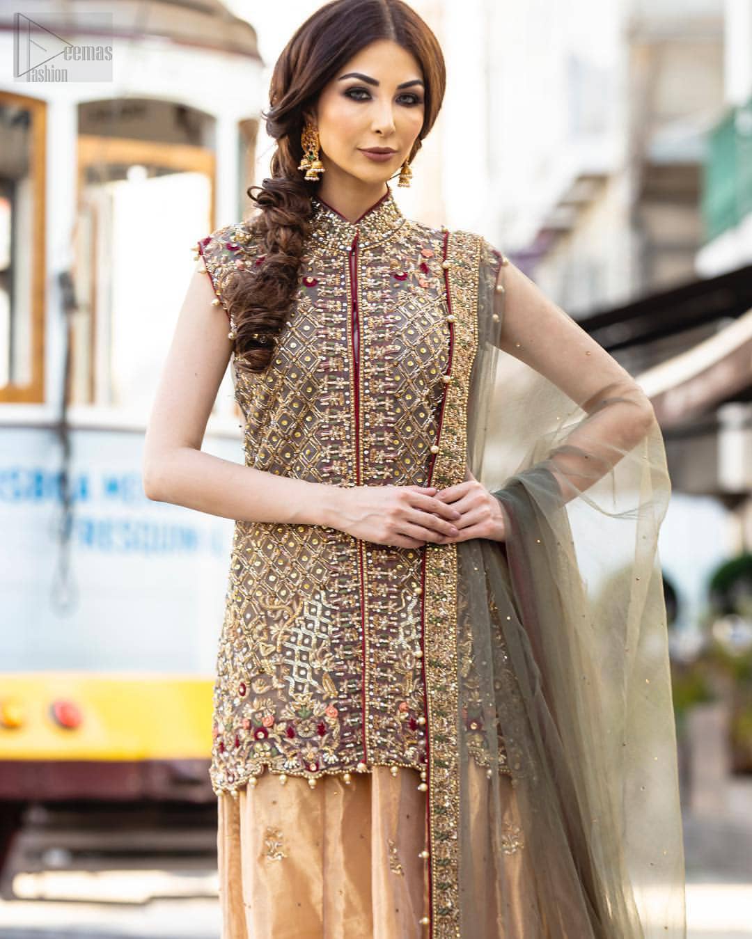 Our selection of wedding dresses offers simple evening glamour dresses. Add a taupe gray color to your wardrobe with our modern styled front open shirt enhanced with embellished geometric patterns. The neckline is beautifully designed with collar neck and scalloped hemline is emphasized with dangling pearls and multiple color embroidery. It is paired with taupe gray dupatta with one sided hand embellished border and sprinkled sequins all over. Compliment the look with fawn lehenga adorned with floral bunches. The combination of fawn and taupe gray is absolutely breathetaking.
