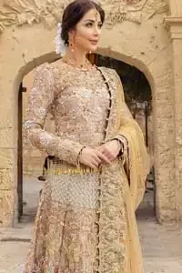 Strike a breathtakingly elegant pose in this wedding dress, designed with a beautiful blouse and a dramatic train. This artisan piece includes intricate hand-embellishment. This highly skilled technique involves hand needle work to add beads, kora, dabka, tilla and sequins to the fabric, giving our garments a unique look. The blouse is also enhanced with tassels on the hemline and back is adorned with horse shie neckline. Zardozi work is done in the shades of golden and silver. Dupatta is decorated with sequins spray on the canvas and finished with embroidered border on four sides which makes this outfit more beautiful.