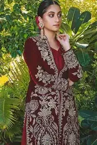 Steal the show with this endearing velvet outfit with intricate yet rich embroidery. The chic yet elegant front open shirt is decorated with embroidered patterns, embellished collar neckline and floral bunches. Hemline is even more enhanced with detailed zardozi work. The back of the shirt has a central large motif on the bodice while the zardozi work creates drama on both front and back panels. Beautifully paired up with maroon palazzo pants. Finish the look with maroon organza dupatta adorned with tiny floral motifs all over.