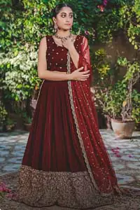 Let the crowd stare and make it worth their while when you walk wearing this maroon velvet lehenga blouse. Designed to flaunt your best features, the sleeveless blouse carries sequins spray with round neckline. Upholding the idea of simple is beautiful, you would definitely want to wear this for your next occasion or on your big day. The blouse is paired with maroon lehenga with hand embellishments on velvet base. The wide flare lehenga hemline is emphasized with intricate details with antique shaded kora, dabka, tilla and sequins work that gives the perfect ending t this outfit. Paired with maroon net dupatta having lace on all four sides.