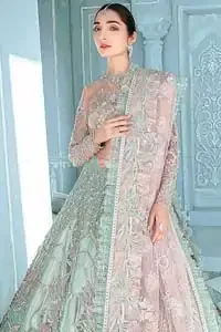 A enchanting amalgamation. This fairytale ensemble is everything that you need to impress everyone. The fusion of rich fabrics intricately designed with floral powdery hue. Precious uncut stones are threaded together with silver zardozi on pastel color palette to give it an enchantingly exquisite look. The illusion neckline blouse is laden with silver kora, dabka details and pair it up with a beautiful lehenga. The lehenga is adorned with colorful chatta patti waist belt and a captivating geometric jaal finished with scattered floral motifs and scalloped hemline. Finish the look with pink dupatta focusing on heavily embellished borders on all four sides to give it a perfect maharani look.