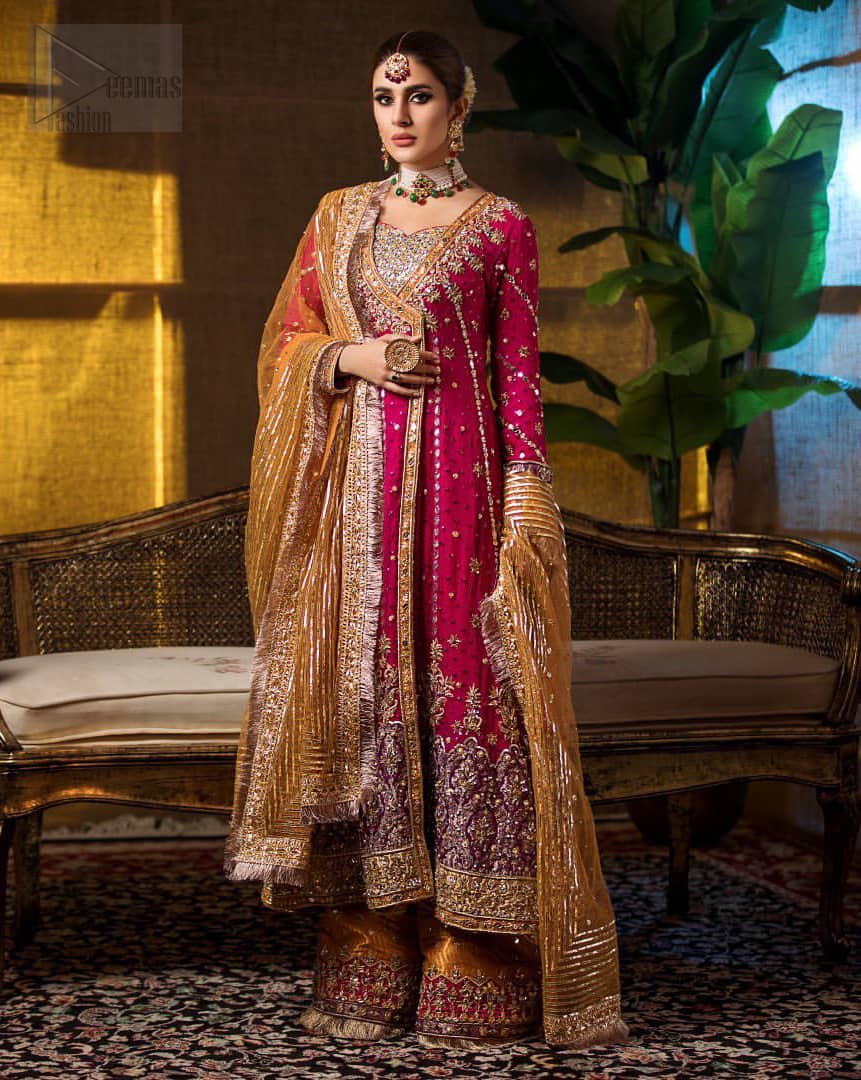 Impeccably on trend. The chic yet elegant front open angrakha style frock is decorated with vertical embroidered lines, embellished neckline and floral bunches. Borders are even more enhanced with rust applique details done with golden and light golden zardozi work. It comes with brocade rust sharara exaggerated with embroidered pink applique on the bottom. Elegance is personified when it gets paired up with rust dupatta decorated with four sided kiran lace and zardozi work on all four sides.