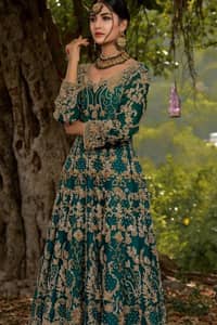 The new season is all about making a statement. Unique craftsmanship and detailed embellishments bring heavenly hued gossamer fabrics to life. Add a charm to your mehndi with an intricately golden embellished bodice and motifs all around the flare on sea green canvas of organza. Daaman is elegantly decorated with embroidered golden floral bootis, sprinkled sequins and beautiful craftsmanship. Pair it up with sea-green sharara having delicate details at the bottom instantly draws attention. To complete the look, go with ivory brocade dupatta.