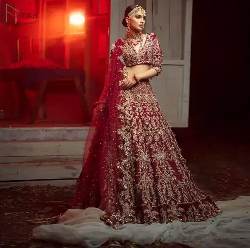 Maroon Pakistani bridal wear half blouse and lehenga comes with dupatta. Deep red half blouse choli along with same colour