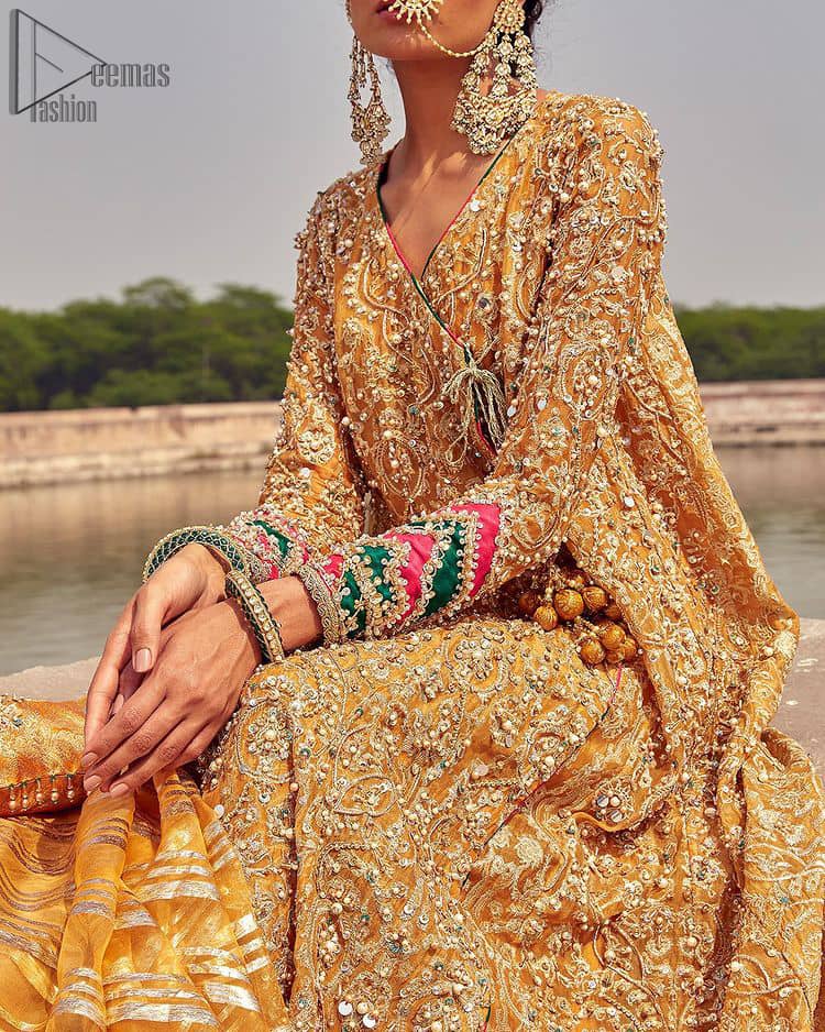 A beautiful touch of light golden embroidery embellished with sparkling pearls follows a fascinating churidar pajama, finally concluding the dress. The Mustard Angrakha Frock is for sure a marvellous choice for Henna.