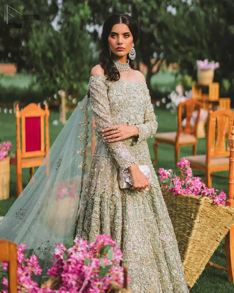 Enhance your beauty by dressing in magic. The most beautiful day of your life deserves an overall dome of perfection, which is why you need a Pastel Green Off Shoulder Blouse to make you look stunning as a bride. This fascinating full-sleeved attire comes with a graceful lehenga, both of which are made with the finest organza to comfort you and make you look fab. Adorned with sparkling pearls, tassels and embellished with silver and golden embroidery, this charming dress aims to glow with utmost perfection. A definite treat to your Nikkah or Walima.