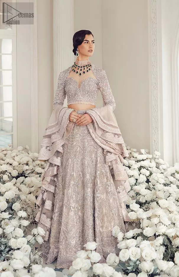 Your wedding day becomes more memorable when the guests are stunned by your majestic beauty and the perfect arrangements that are made. The Cream Lehenga Blouse is designed with such dexterity as to make you one gorgeous-looking bride on your big day. The dress code demands a full-sleeved blouse with a unique sweetheart neckline. Its exquisite fawn colour is meritoriously adorned with superb silver embroidery and stylish tassels, which are indeed the most graceful works of matching embellishment. When it comes to the definition of elegance, the purest organza is specifically reserved for the creation of such marvellous attire. Followed by a beautiful dupatta and a lehenga, this charming bridal wear will make your Walima or Nikkah a heavenly day.