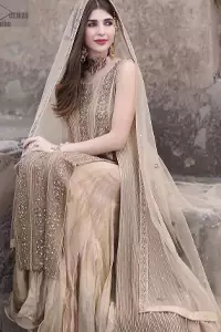 Captured in a traditional silhouette, this bridal wear stands out due to its uniqueness, the perfect fusion of modern cut and traditional embroidery. The Beige Long Shirt Sharara is beautifully decorated with heavy embroidery and adorned with kora, dabka, tilla, sequins and pearls. It comes with pure chiffon sharara, followed by an organza dupatta which is sprinkled with sequins all over it. It is further furnished with a one-sided border. This marvellous attire will beautify your looks on your memorable Nikah day.