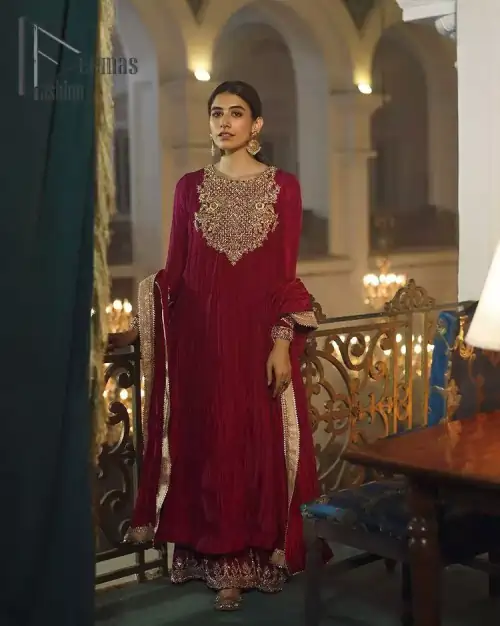 A picture of pure elegance with maroon crushed frock enhanced with embellished golden embroidered neckline. The neckline is adorned with