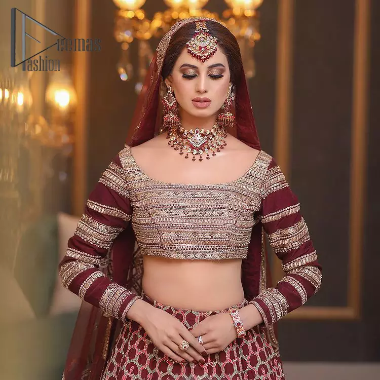 Attain your expectations on your big day with this mesmerizing dress. The classically vibrant combination of red and gold is a true image of elegance. The full-sleeved red blouse made with pure organza is encapsulated with boat shape neckline that follows light golden embroidery. In addition to this, the lehenga having geometric pattern embroidery that embellishes with tilla , dabka and kora work gives you incredible look on your big day. This engaging dress comes with a dupatta having four sides embellishment borders.