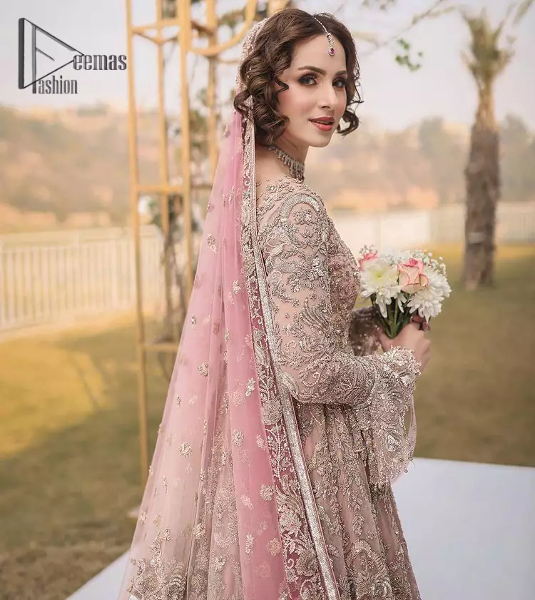 There is nothing more magical than wearing pink color on your walima. Our pink side slit open maxi is handsomely embellished with the magic of silver embroidery that involves kora, antique, dabka , sequins, and pearls just to give you dream fairy look. Further, the back train of the maxi is granted you the super dazzling effect. It is beautifully organized with a pink dupatta that is embellished with four-sided borders. Further, the dupatta is highlighted with the spray of tiny floral motifs all over just to enhance the fairy look.