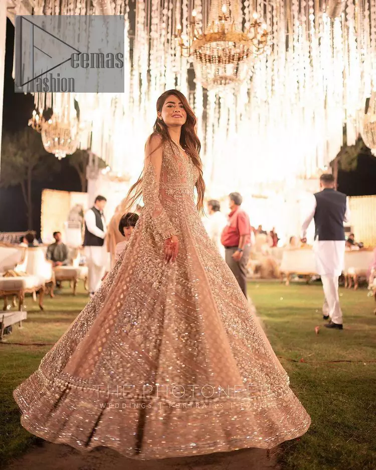 Its lustrous, lush and lavish in every sense of the word with its dazzling nude peach base. The nude peach multiple panel frock is amazing for your walima day. The V shape neckline is heavily embellished with embroidery. Further, this aesthetic nude peach frock is enhanced with silver pearls, tilla and dabka work. It is prominent with full sleeves that give a soothing effect to this article. It is complete in its pleasing loudness with an equal nude peach sharara that is adorned with silver embroidery just to fulfil the fairy dream of every bride. 