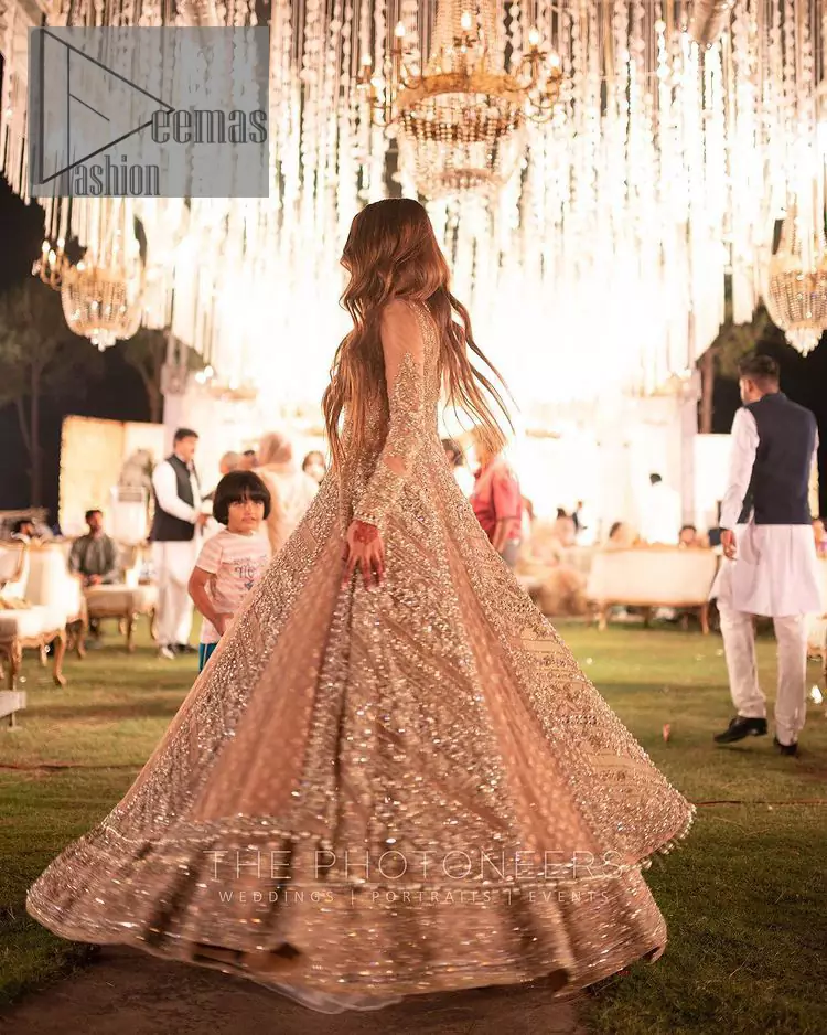 Its lustrous, lush and lavish in every sense of the word with its dazzling nude peach base. The nude peach multiple panel frock is amazing for your walima day. The V shape neckline is heavily embellished with embroidery. Further, this aesthetic nude peach frock is enhanced with silver pearls, tilla and dabka work. It is prominent with full sleeves that give a soothing effect to this article. It is complete in its pleasing loudness with an equal nude peach sharara that is adorned with silver embroidery just to fulfil the fairy dream of every bride. 