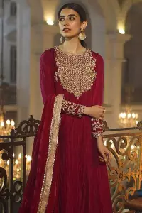 A picture of pure elegance with maroon crushed frock enhanced with embellished golden embroidered neckline. The neckline is adorned with golden kora, dabka and tilla work. Beautifully paired up with palazzo delicately crafted with embroidery on the border. With a lot of attention to detail, the intricate zardozi work using zardozi work and tilla makes the dress look like nothing but a dream. Dupatta is emphasized with lace all around the borders.