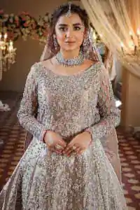 Amplify your style on your Walima day in this stunning light color. DeemasFashion presents the super handsome rose gold outfit for you. First of all, which includes back train maxi in the rose gold colour. It is prominent with the silver embroidery that is encrusted with pearls, silver crystals, kora, dabka and sequins all over highlighting floral patterns. Further, it is emphasized with boat shape neckline and full sleeves that increase the opulent statement of the outfit. It is organized with rose gold sharara which is also embellished with heavy silver embroidery to make your day super dazzling. Finish this look with the rose gold dupatta that is accentuated with sequins and booti spray all over and adorned with a four-sided matha Patti border. 