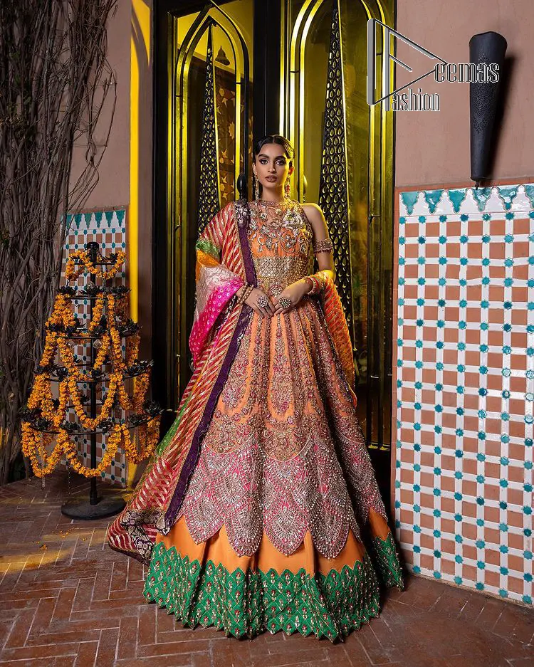 In a world full of trends, sometimes a bride just wants to wear something classic and traditional. In this way, DeemasFashion presents the major Pakistani walima dress which is nearest to the traditional style. The Pakistani walima dress starts from the orange pishwas which is beautifully styled with an illusion neckline and sleeveless. Further, it is enhanced with colourful embroidery which includes kora, dabka, tilla and Sitara to make your day super special. Pakistani walima dress is systemized with lehenga in the same colour but has a heavy green border to add beauty to the dress. Complete this Pakistani walima dress with a colourful dupatta to meet the following traditional trend.