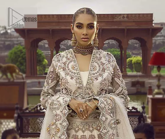 This vibrant canvas is all your brides need to cheer in at your special Nikah moments. A beige white blouse has a V shape neckline and full sleeves embellished with golden and silver embroidery. It is further intensified with special tills, dabka, kora, Kundan and the magic of zardozi to make your day outstanding and more funable. It is paired up with embroidered scalloped lehenga to fulfil the dreamy fairy look of the bride. Complete this article with a scalloped dupatta in the same colour with a four-sided embellished border and sequins sprayed all over to cheer up.